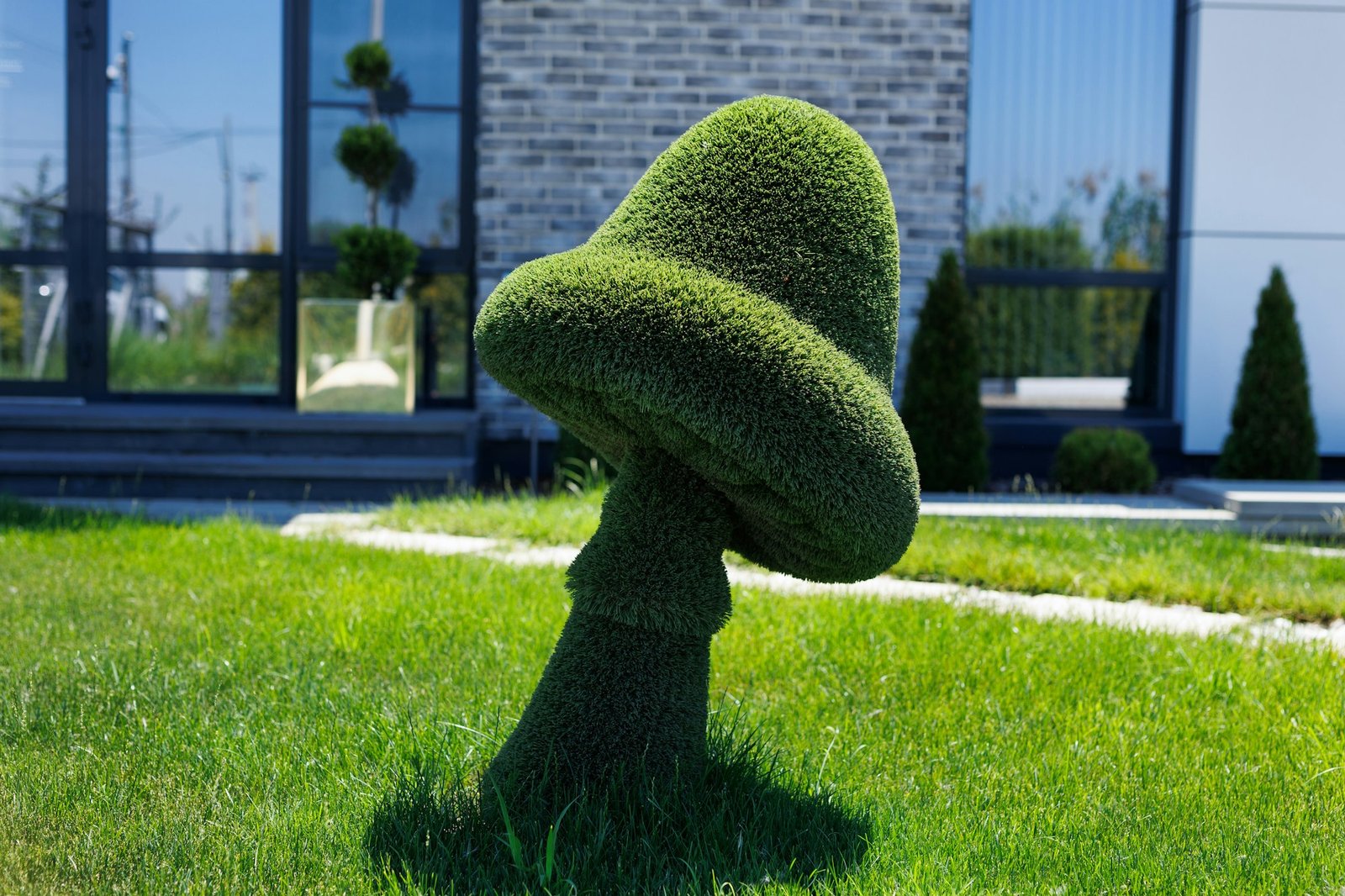 A statue of a mushroom made of lawn grass. Landscape design.