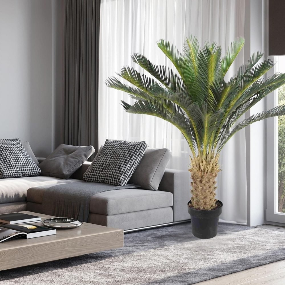 Artificial sago palm tree with a gold ribbon around the trunk, displayed in a contemporary living room