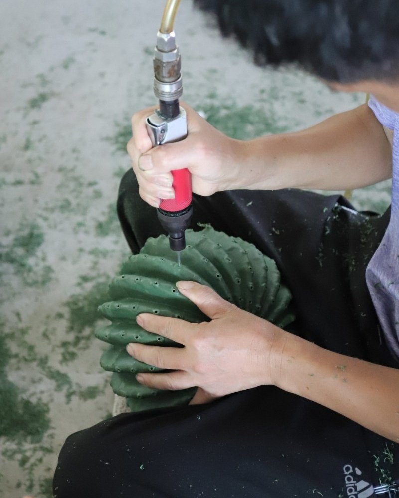 Worker handcrafting artificial cactus plant
