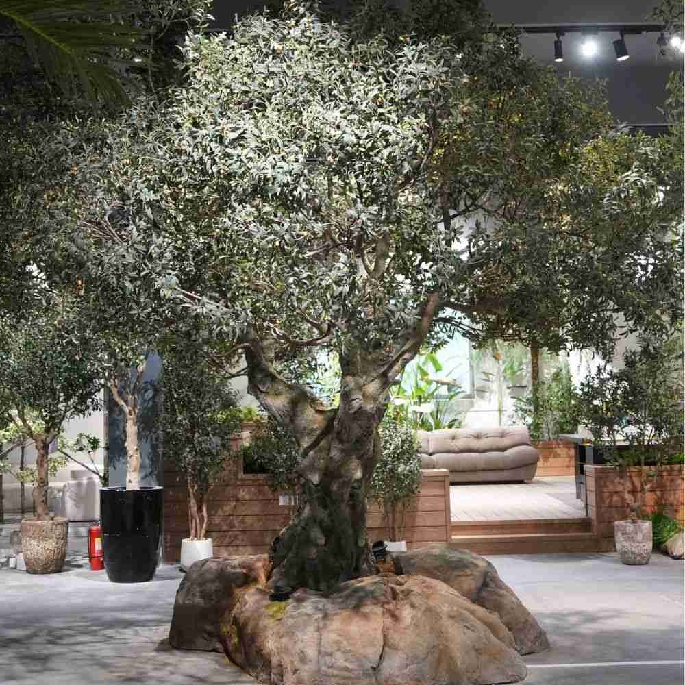 Grand-scale artificial olive tree with hand-sculpted trunk and steel-reinforced structure for hotel lobby landscaping project.