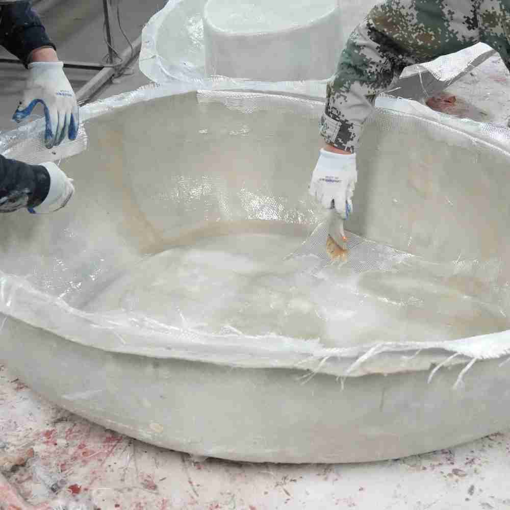 The internal fabrication process of a large-diameter bespoke planter using high-strength fiberglass molding techniques in the Oakco factory.