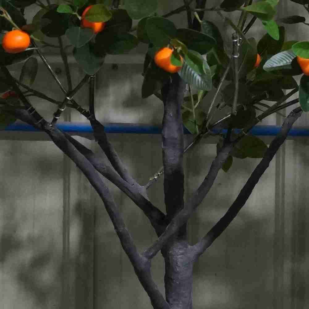 The realistic, textured trunk and branching structure of an Oakco premium artificial orange tree.