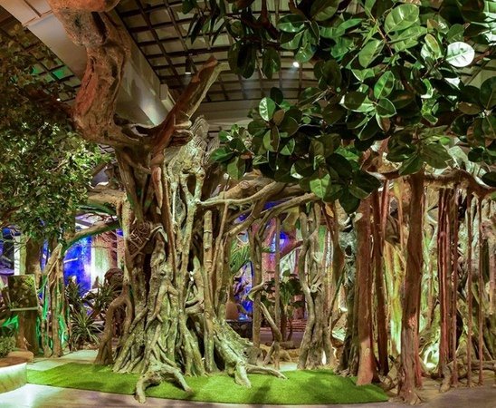 Artificial banyan tree installation in a themed interior display space with dramatic aerial roots and custom trunk design