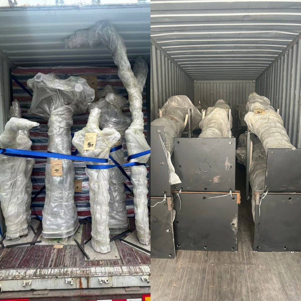 Packed artificial tree trunks and steel bases loaded into shipping container for overseas delivery