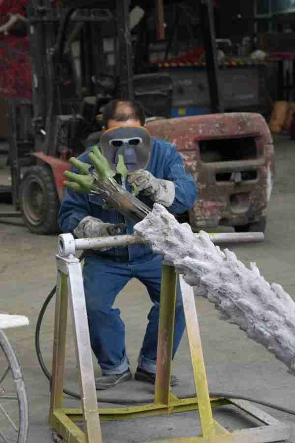 Skilled artisan welding the heavy-duty internal frame for Oakco commercial trees.