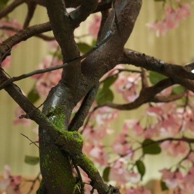 Detailed view of artificial blossom tree branches with moss effect and natural bark texture for decorative projects
