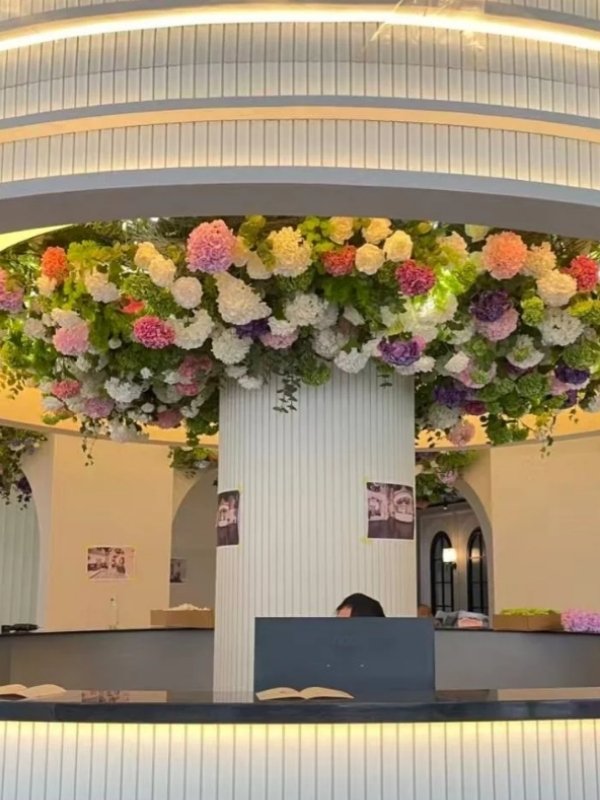 Colorful artificial floral ceiling installation with hydrangea flowers and greenery for hotel lobby, reception, and commercial projects