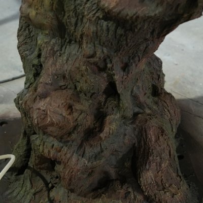 Close-up of realistic artificial tree root and trunk base with aged bark texture for custom faux tree projects