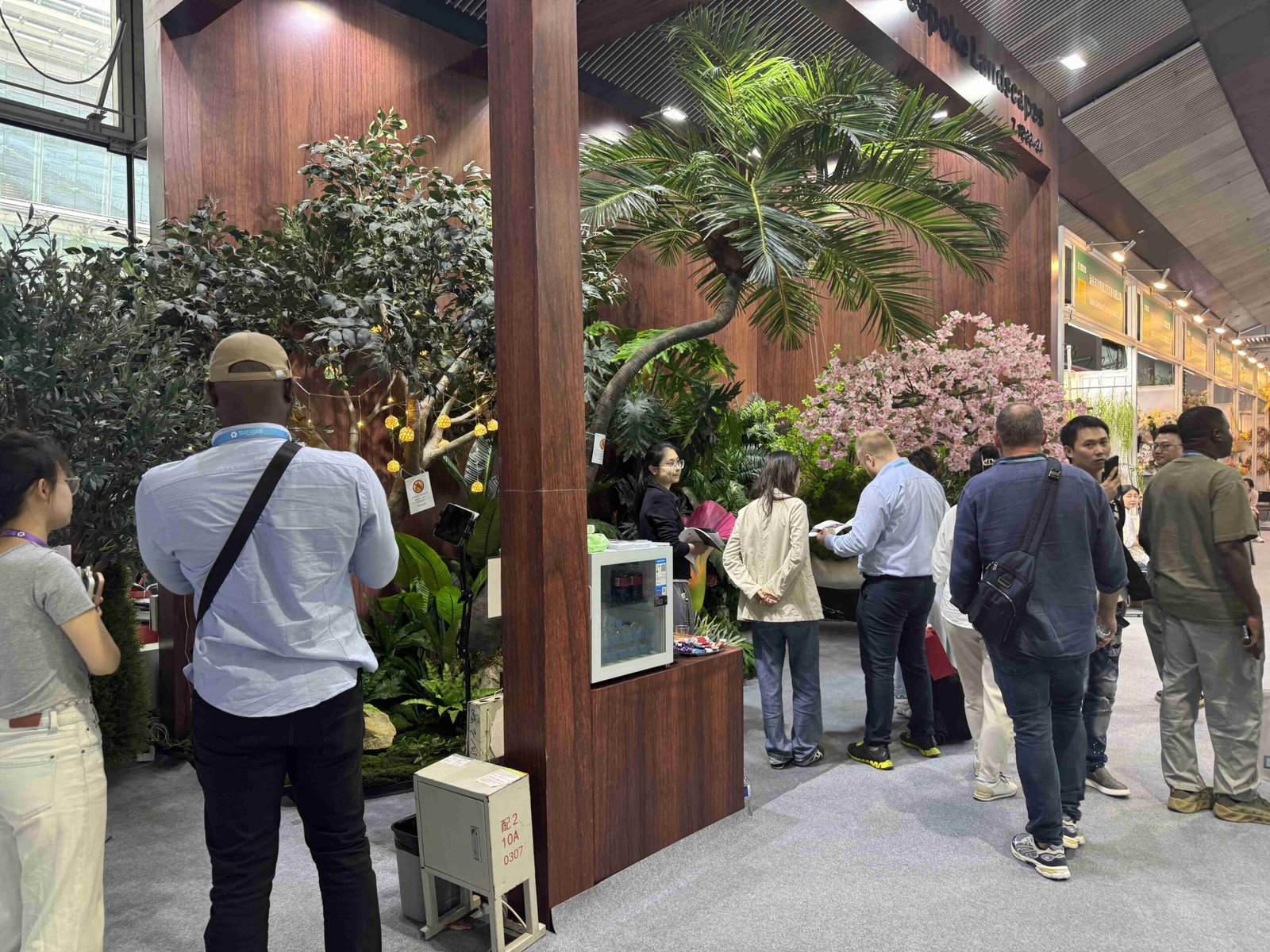 Oakco Canton Fair booth with artificial trees flowering displays and layered commercial greenery