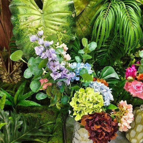 Close-up of Oakco artificial greenery, tropical foliage, and colorful artificial floral display showcased at the 139th Canton Fair for commercial landscaping projects.