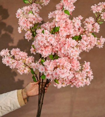 Artificial cherry blossom distribution detail Artificial cherry blossom clusters arranged across a branch