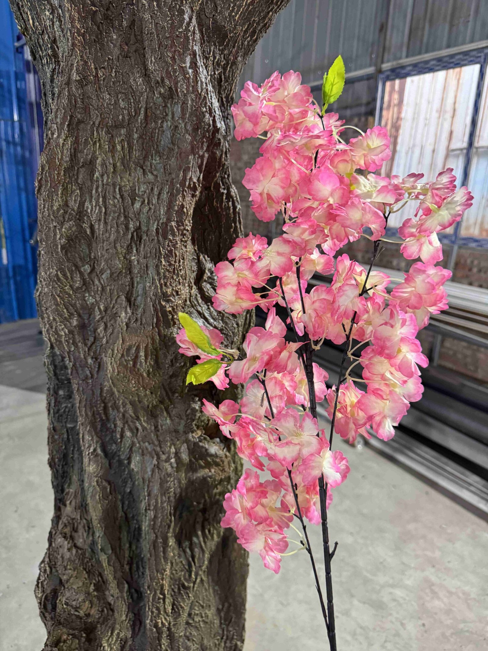 Close-up view of pink artificial cherry blossoms and branch detail