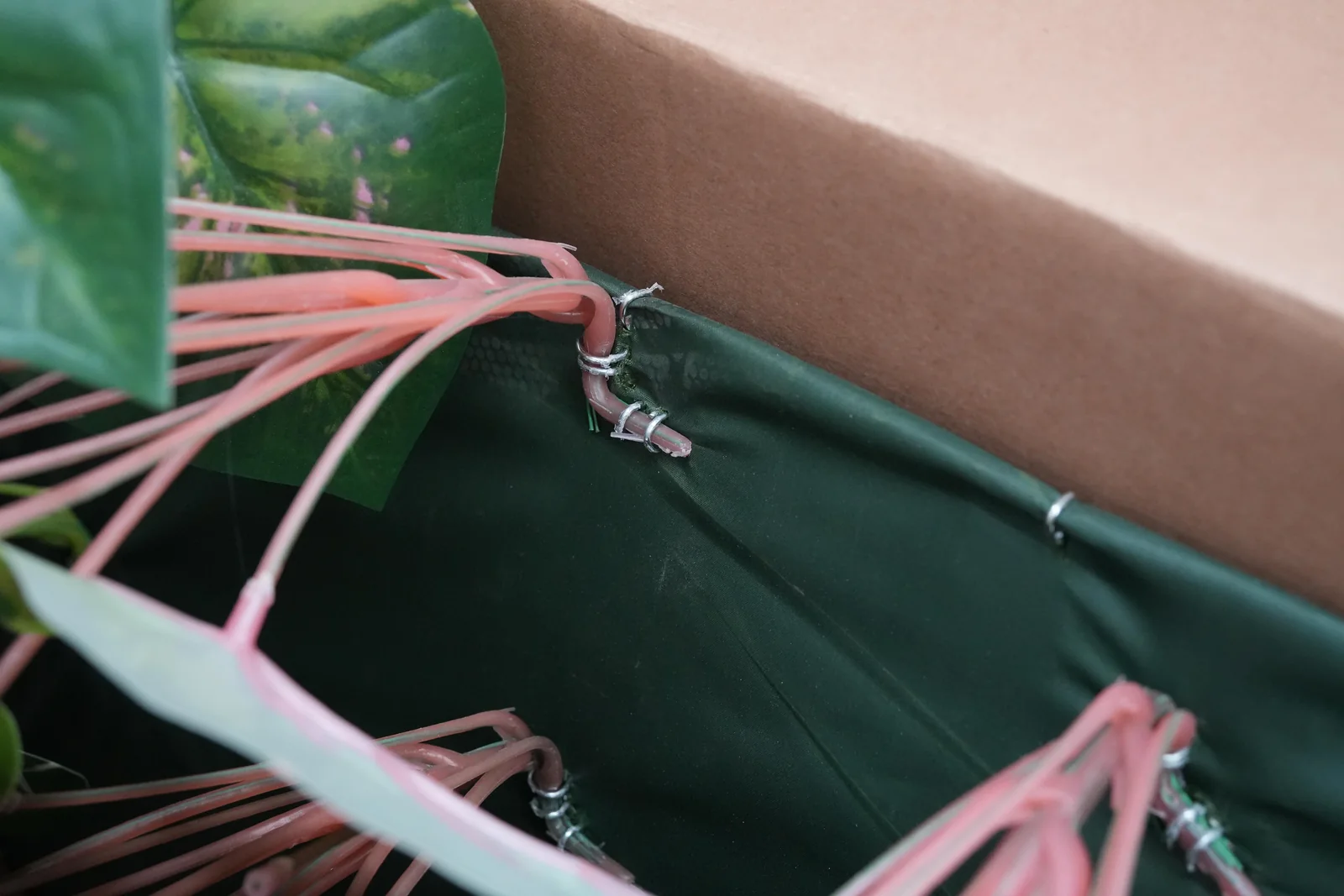 Artificial foliage stems wired to wall mesh