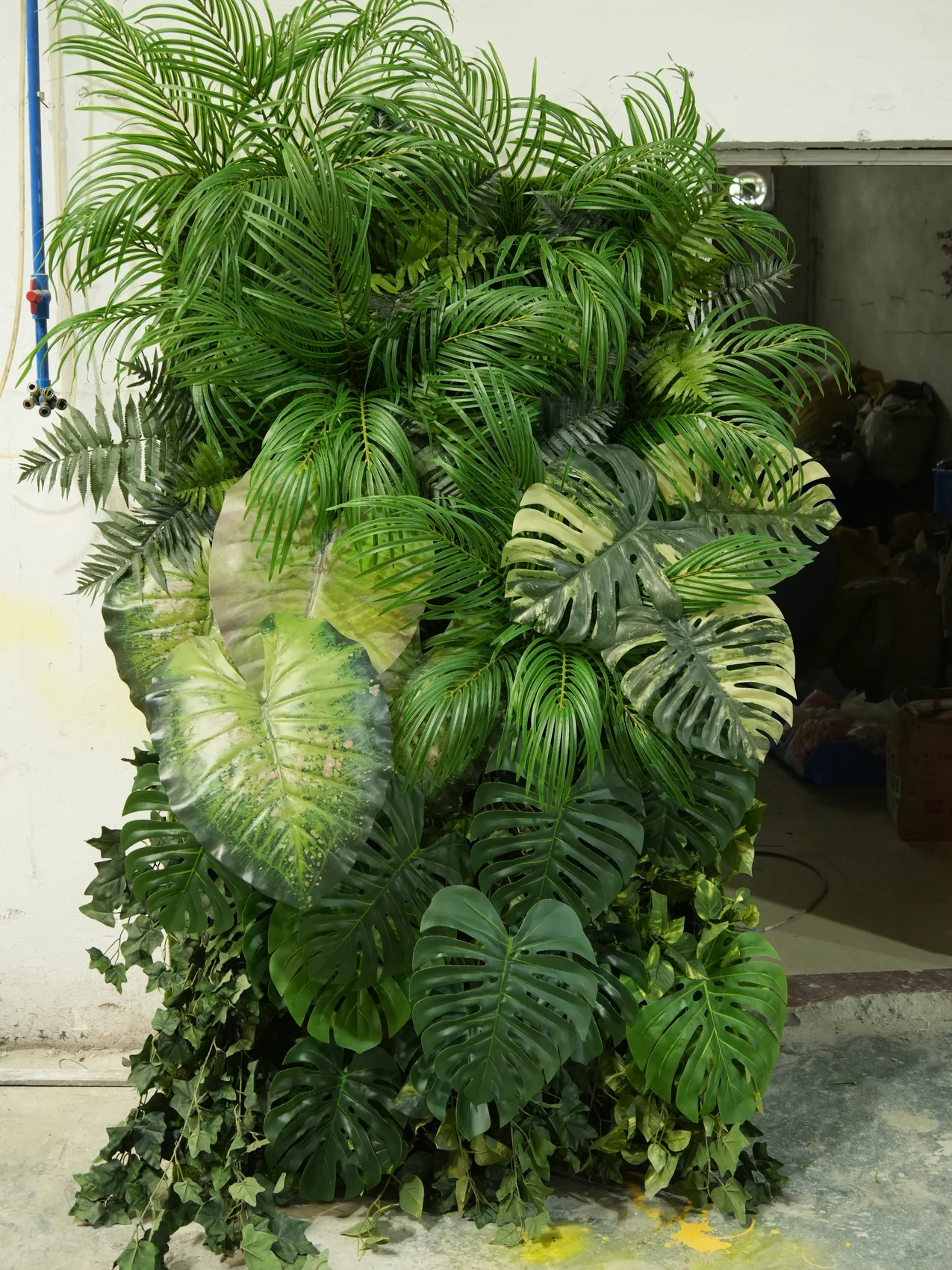 Tropical artificial green wall with layered foliage