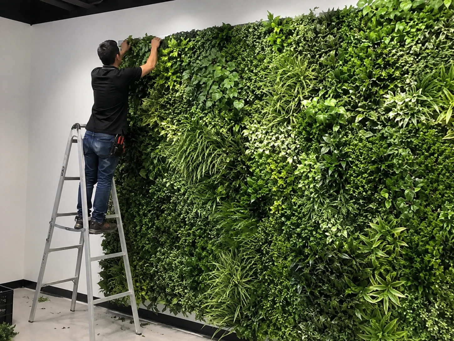 Artificial green wall panel installation for a commercial interior