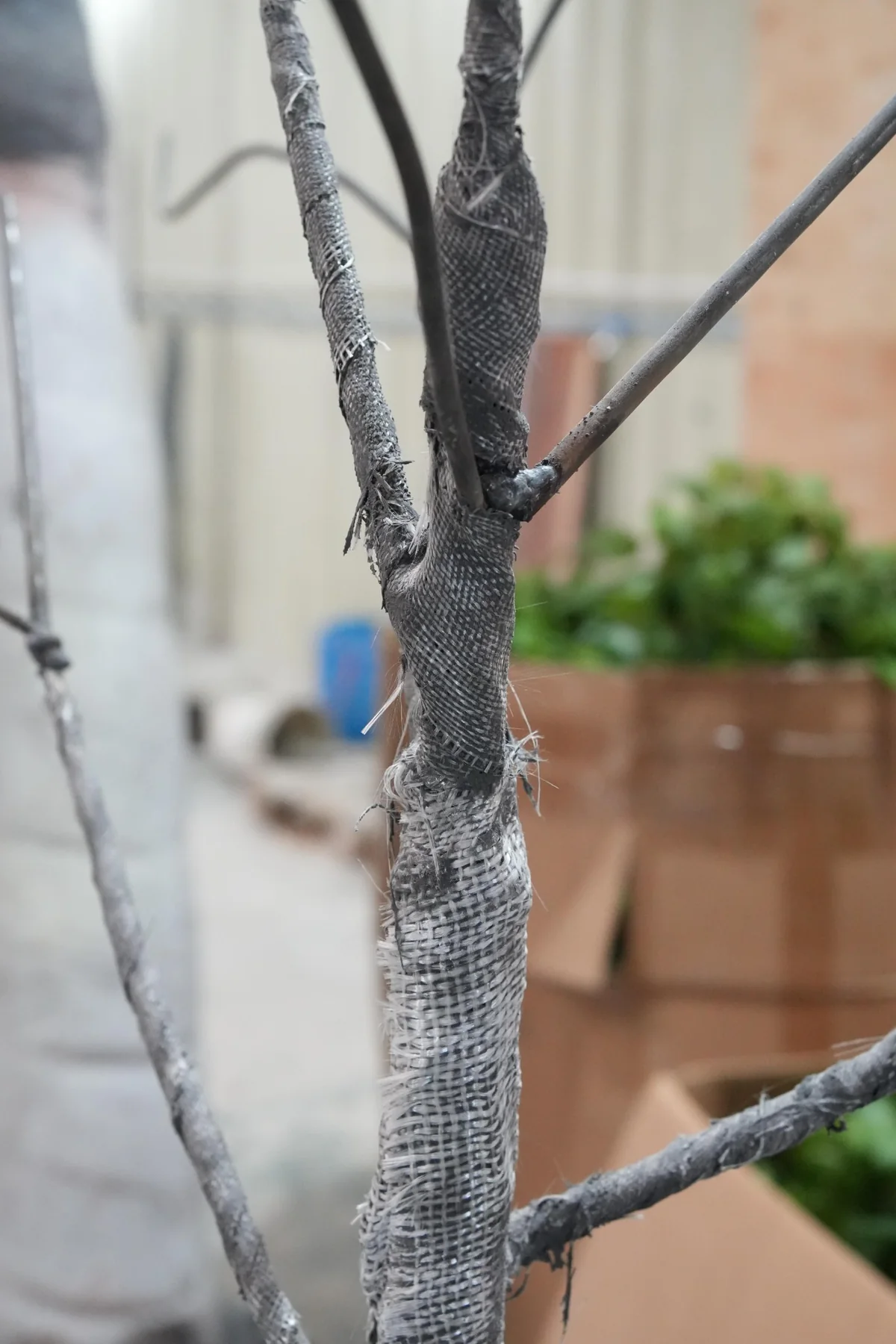 Fiberglass fabric wrapped around the trunk and branches of an artificial orange tree during production