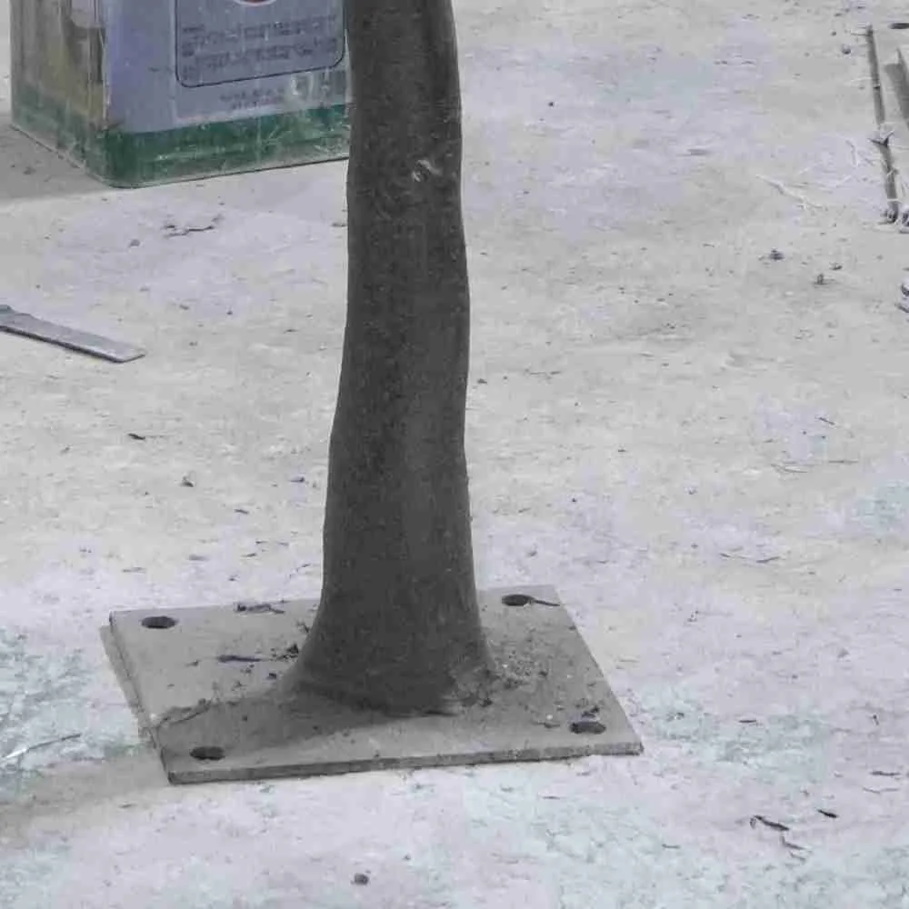 Steel base plate supporting a commercial artificial orange tree