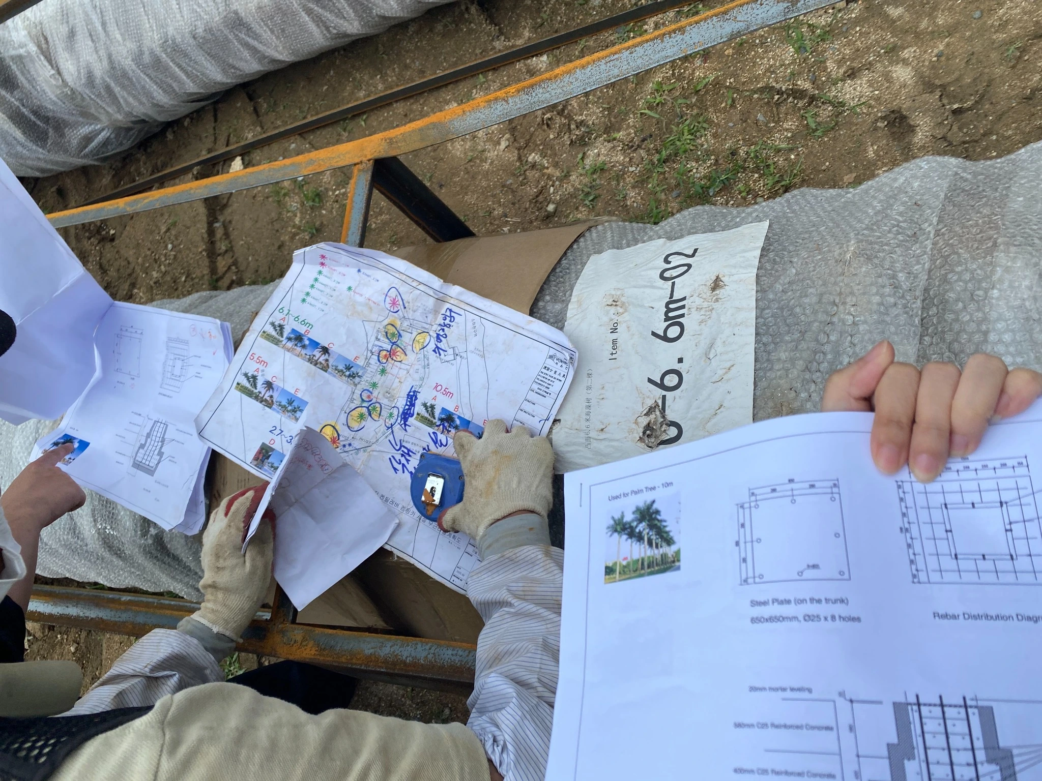 Oakco team checking installation drawings during an artificial palm tree project in Busan, South Korea