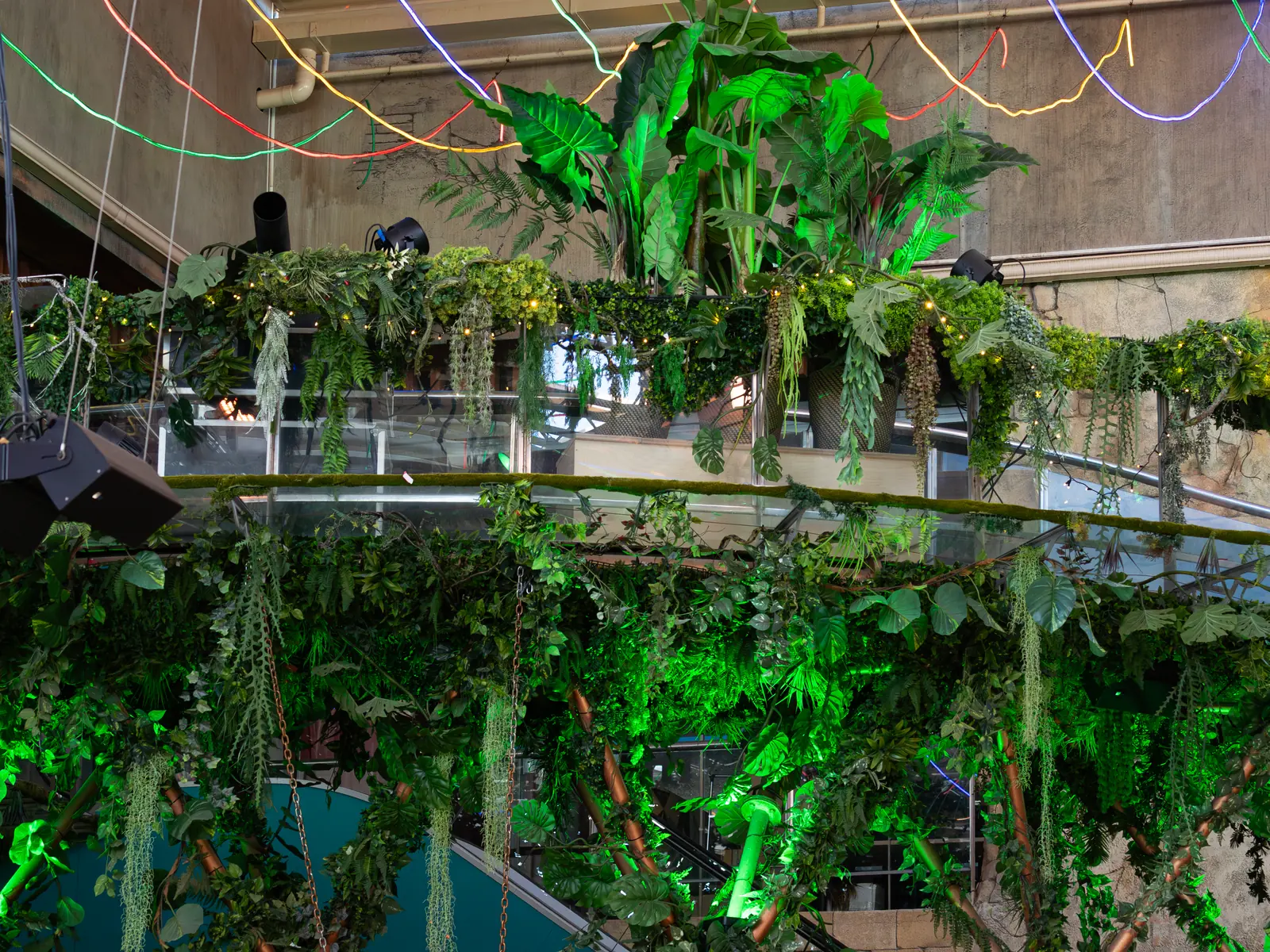 Layered artificial ceiling plants and railing greenery in a hospitality interior in Spain in 2025