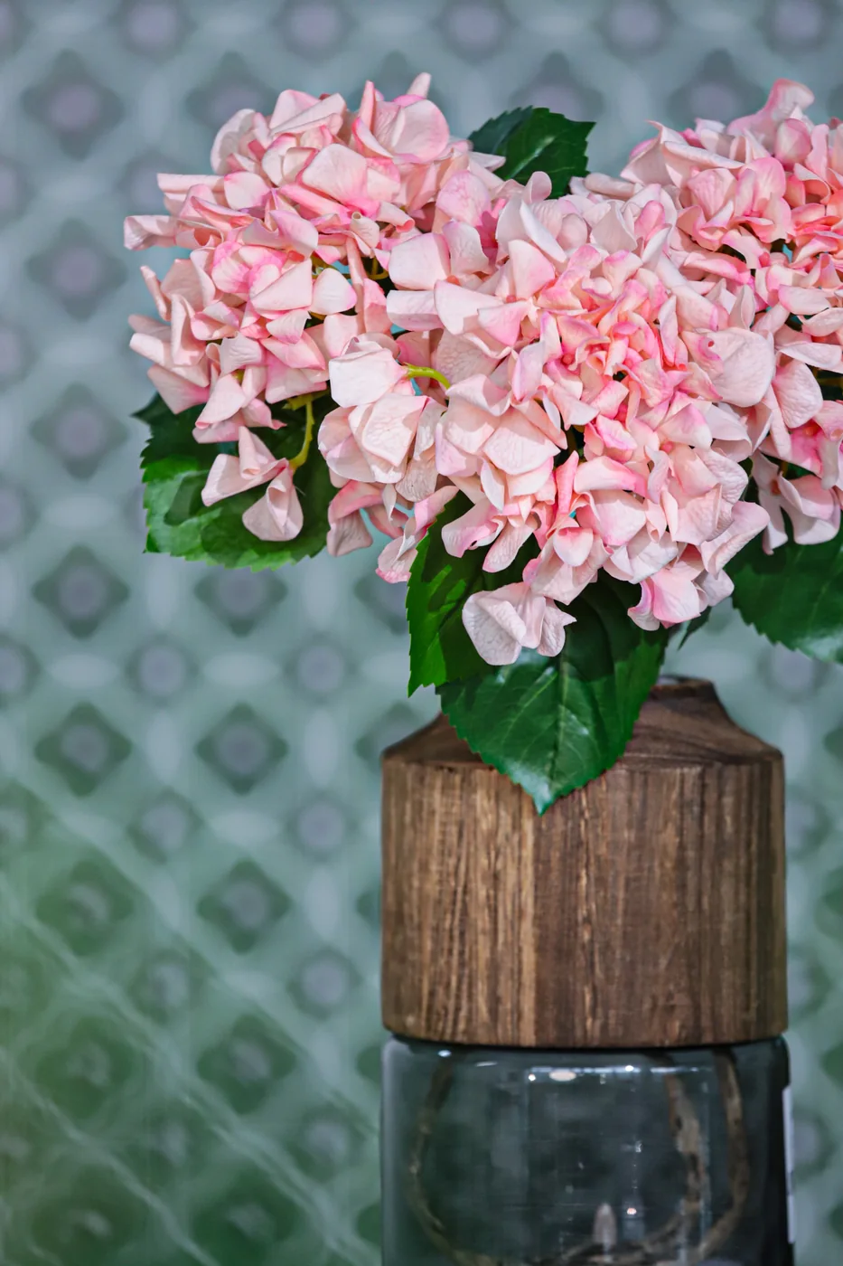 Pink artificial hydrangea arrangement displayed in a textured vase