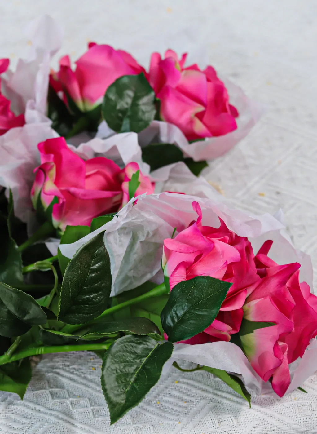 Pink artificial roses showing flower form leaves and colour variation