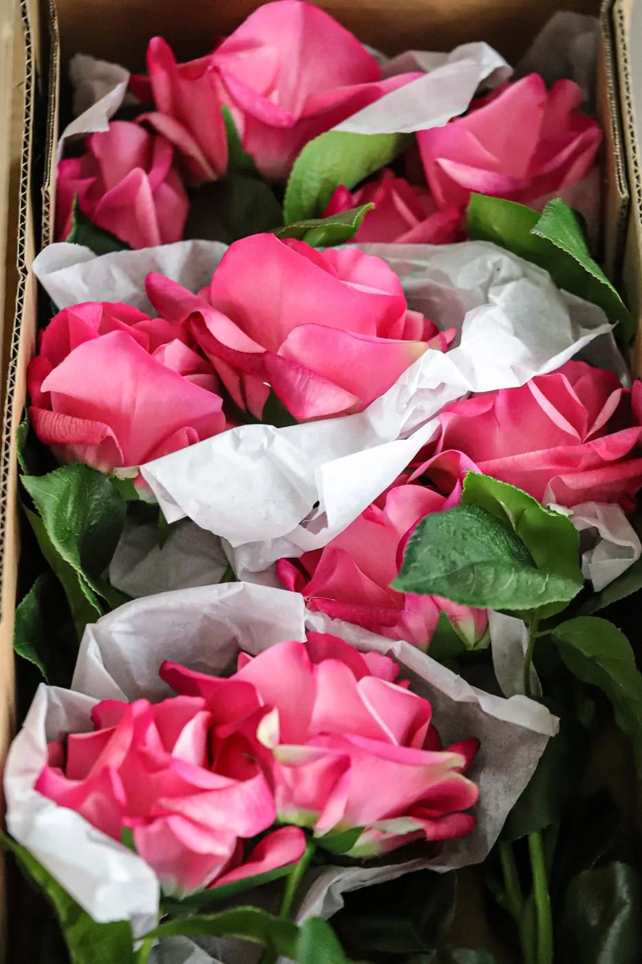 Pink artificial rose heads prepared for packing and sample review
