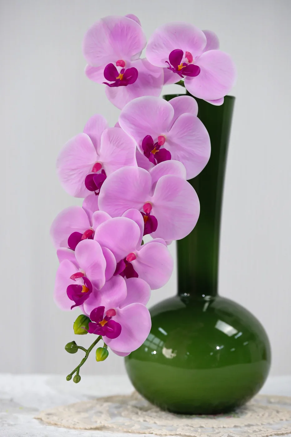 Pink real-touch Phalaenopsis orchid stems arranged in a ceramic vase