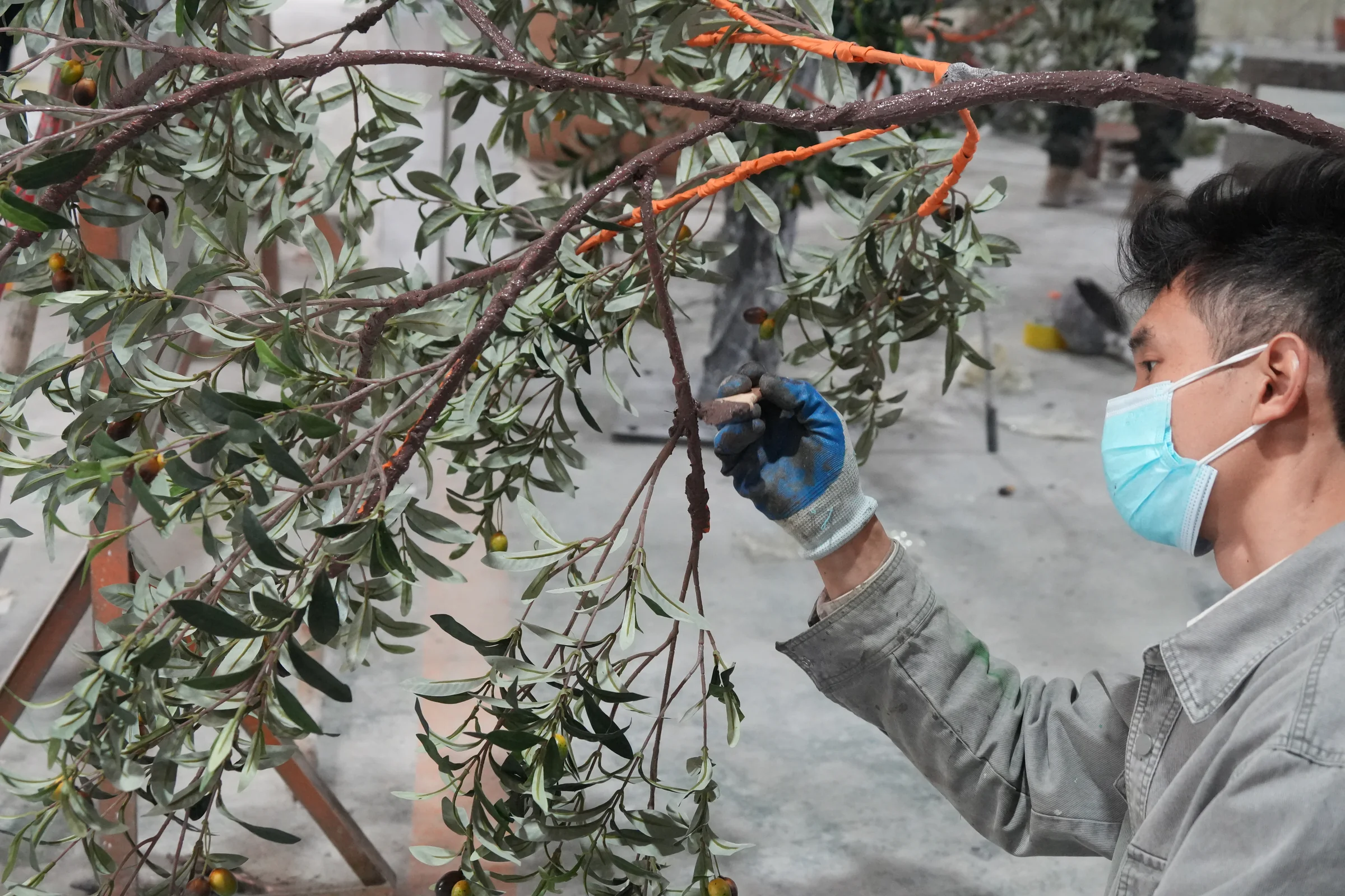 Oakco team assembling and finishing a large artificial tree in the factory