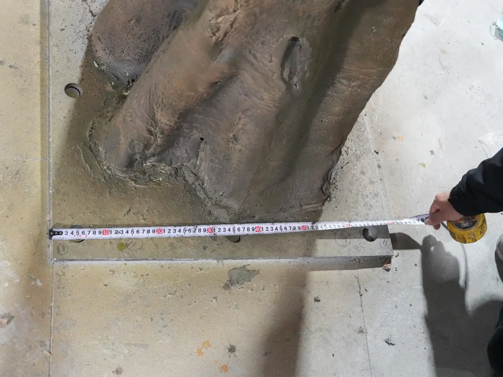 Oakco technician checking the base dimensions of a custom artificial tree during final quality inspection