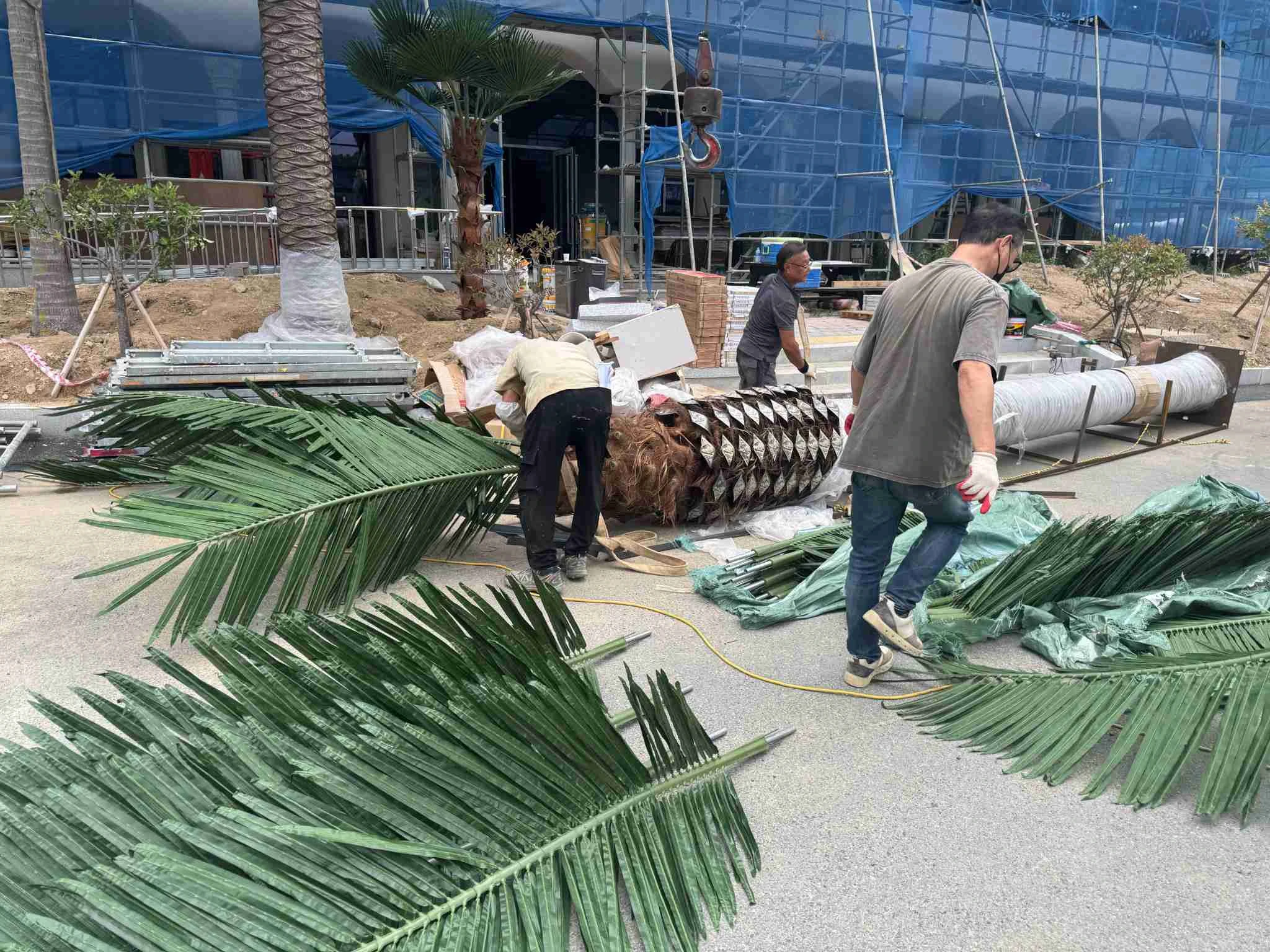 Artificial palm fronds organised for on-site installation