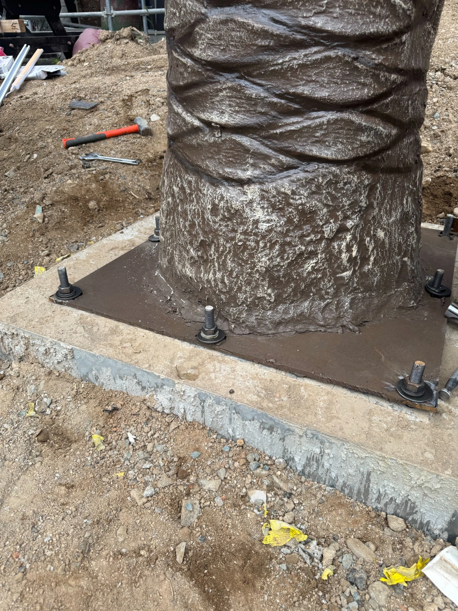 Anchor bolts securing an artificial palm tree base plate