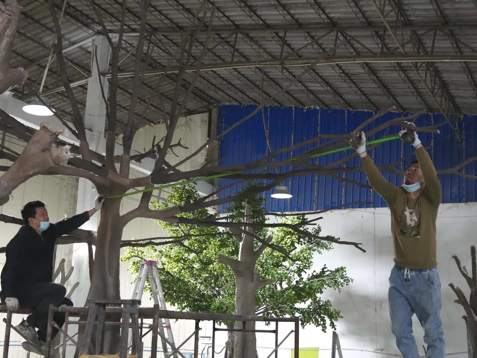 Oakco technicians assembling a large custom artificial tree inside the factory