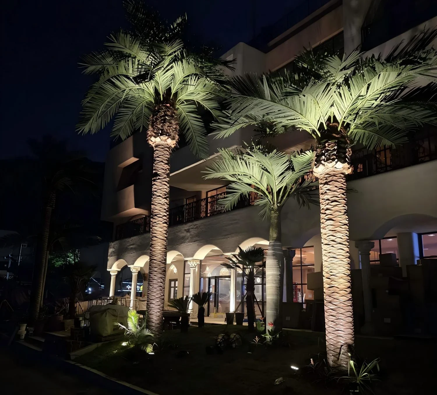 Outdoor tropical landscape created with large artificial palm trees