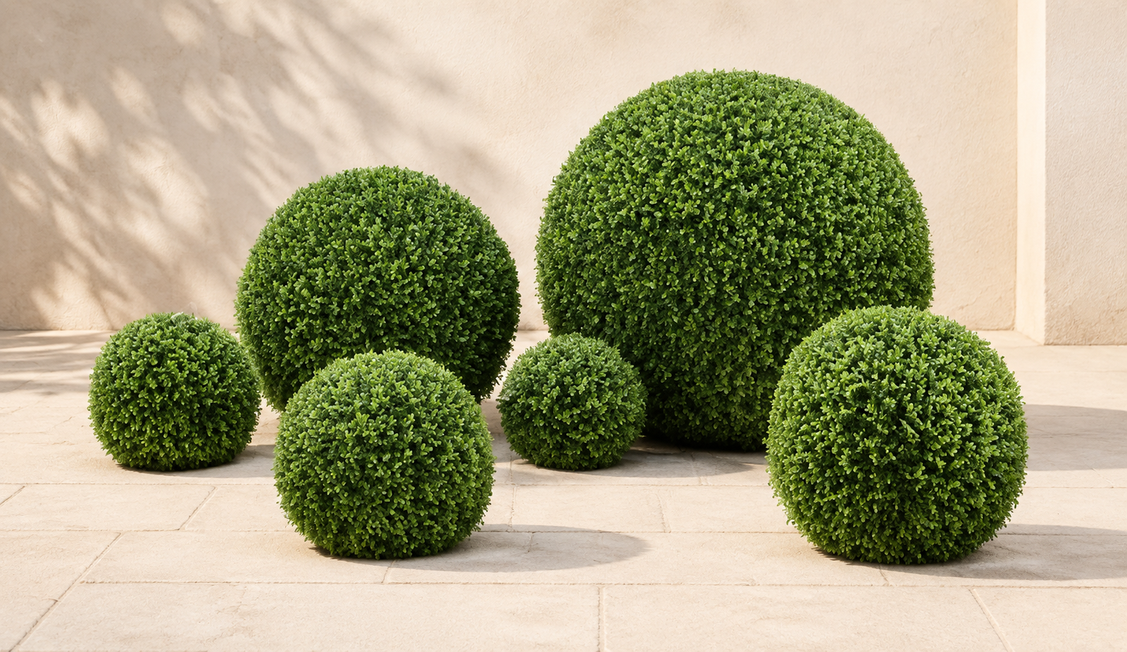 Artificial green topiary balls arranged on a modern patio