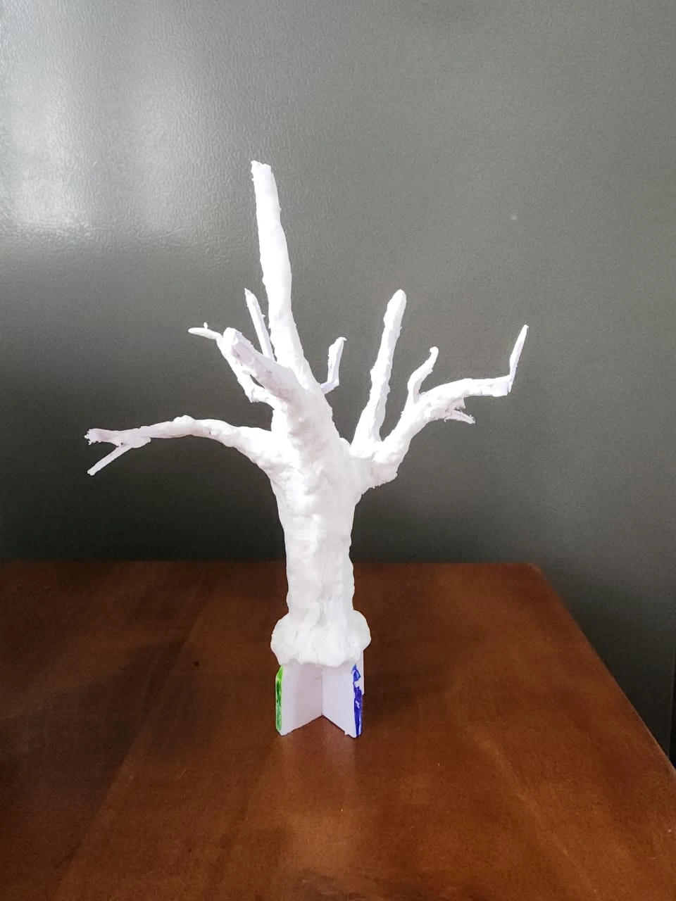 Hand-shaped white clay model showing the requested trunk form for a custom artificial olive tree